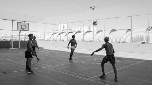 Jogadores de futebol a jogar numa quadra exterior com uma bola no ar.