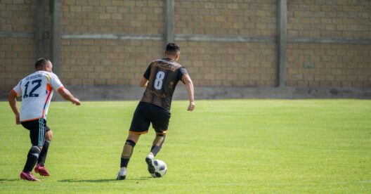 Dois jogadores de futebol competindo durante uma partida em um dia ensolarado em Texcoco, México.