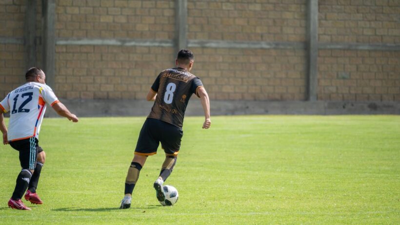Dois jogadores de futebol competindo durante uma partida em um dia ensolarado em Texcoco, México.