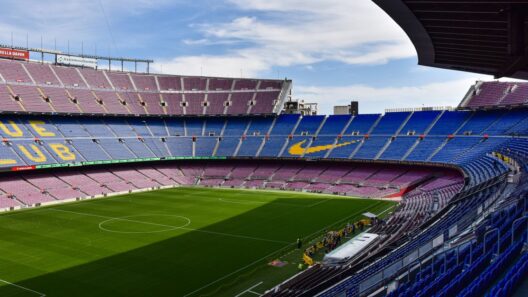 Estádio Camp Nou do FC Barcelona com as bancadas azuis e vermelhas e o relvado verde.
