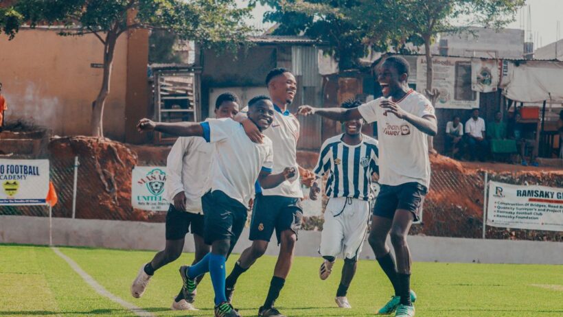 Jovens jogadores de futebol a celebrar num campo