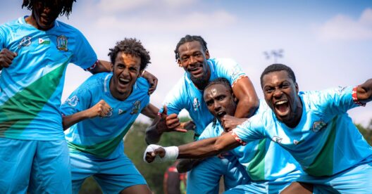 Jogadores de futebol africanos a celebrar um golo em campo.