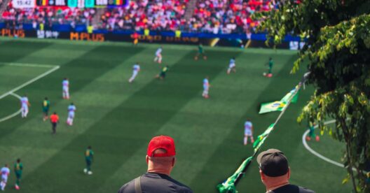 Jogo de futebol com espectadores e bandeira de Angola